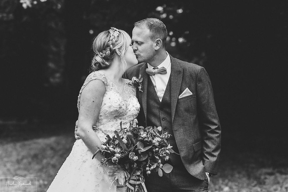 Bride and Groom kissing in the grounds after their wedding at Adel Parish Church in Leeds, Yorkshire