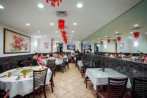 Chinese restaurant interior with tables, diners, decorations, and The Taste of North China.