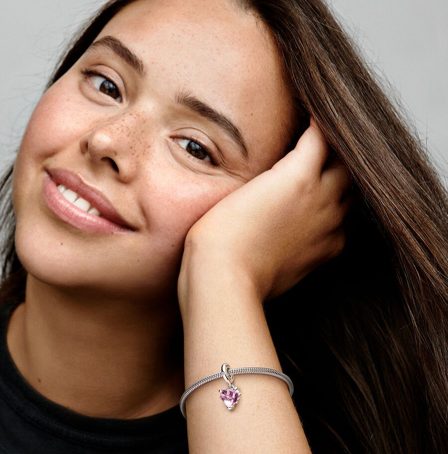 Smiling woman holding arm with bracelet; Jewels by the Sea.