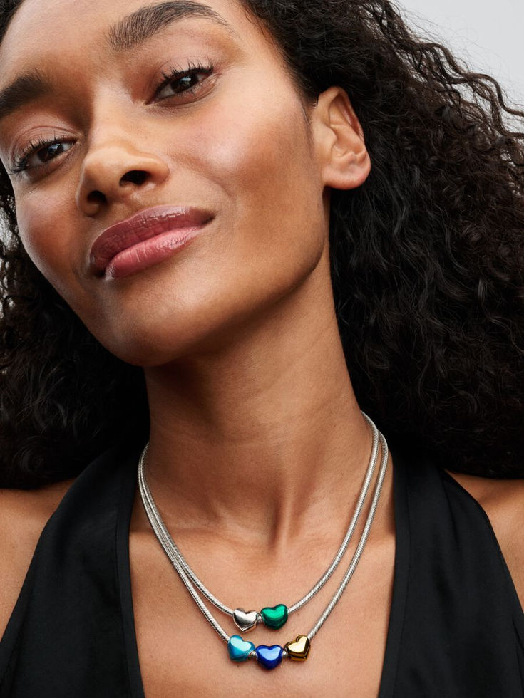 Smiling woman wearing silver necklace with green gemstone, Jewels by the Sea.