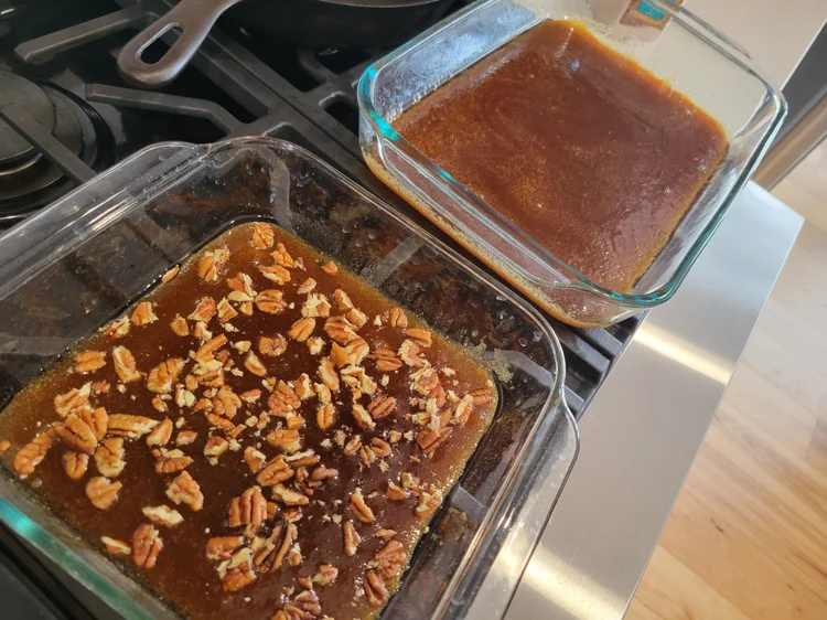 Homemade dairy-free caramel sauce poured into a glass 9x13 baking dish before adding cinnamon rolls.