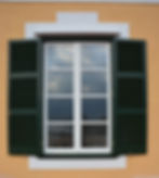 Ventana blanca tradicional con persianas color verde Menorca