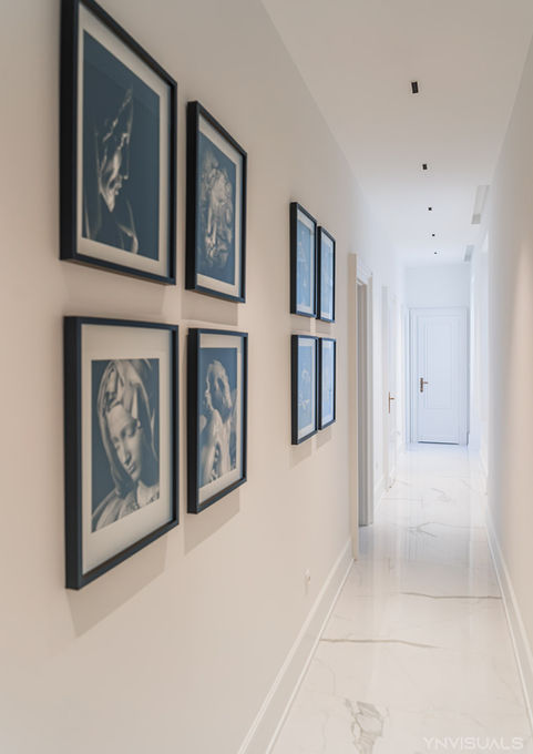 Couloir blanc traversant avec 4 tableaux formant perspective