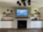 Creating a feature wall from scratch, with gas fireplace and custom shelving.