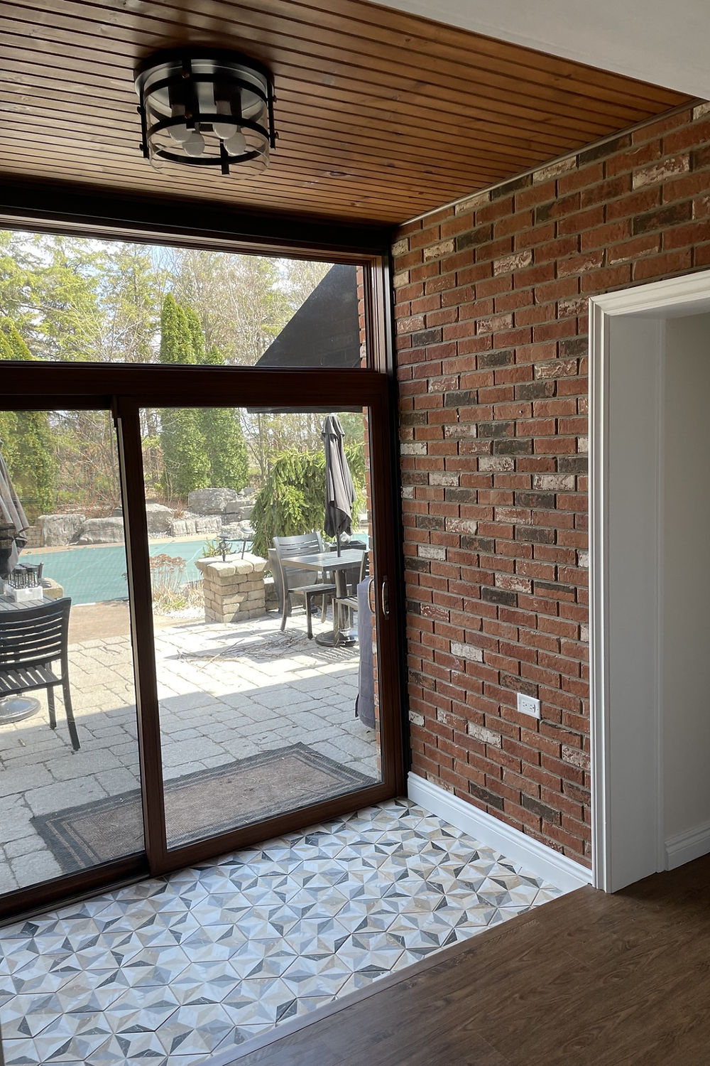 Refinished entryway with modern tile and open concept sliding doors.