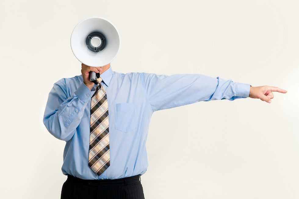 Person in blue shirt with striped tie holding megaphone, pointing to the right. Neutral background, conveying direction or instruction.