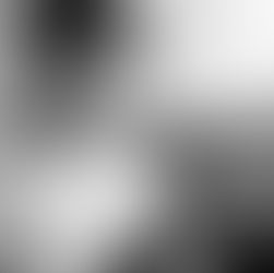 Young person with headphones sits on a couch, focused on a tablet. Wearing a white shirt, the mood is relaxed and studious. Grayscale image.