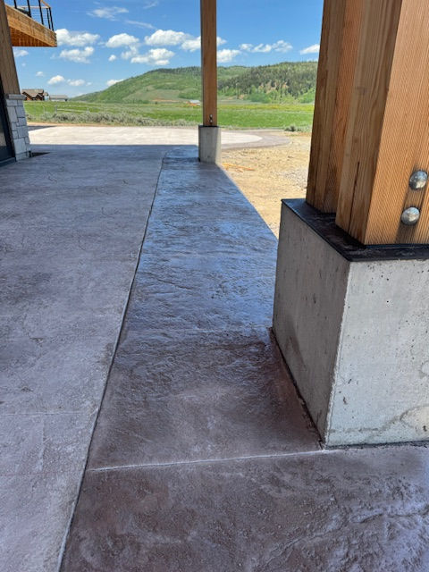 Close up photo of stamped concrete with green hills and blue sky in the background