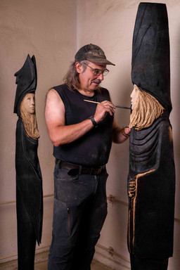 Detailaufnahme einer Holzskulptur: Die rohe Struktur des Holzes und die präzise Führung der Kettensäge, dokumentiert als echtes Handwerk.