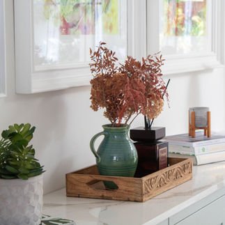 Styled shelf with ceramic vase, dried botanicals and indoor plant in a luxury London home, creating a calm biophilic interior detail.