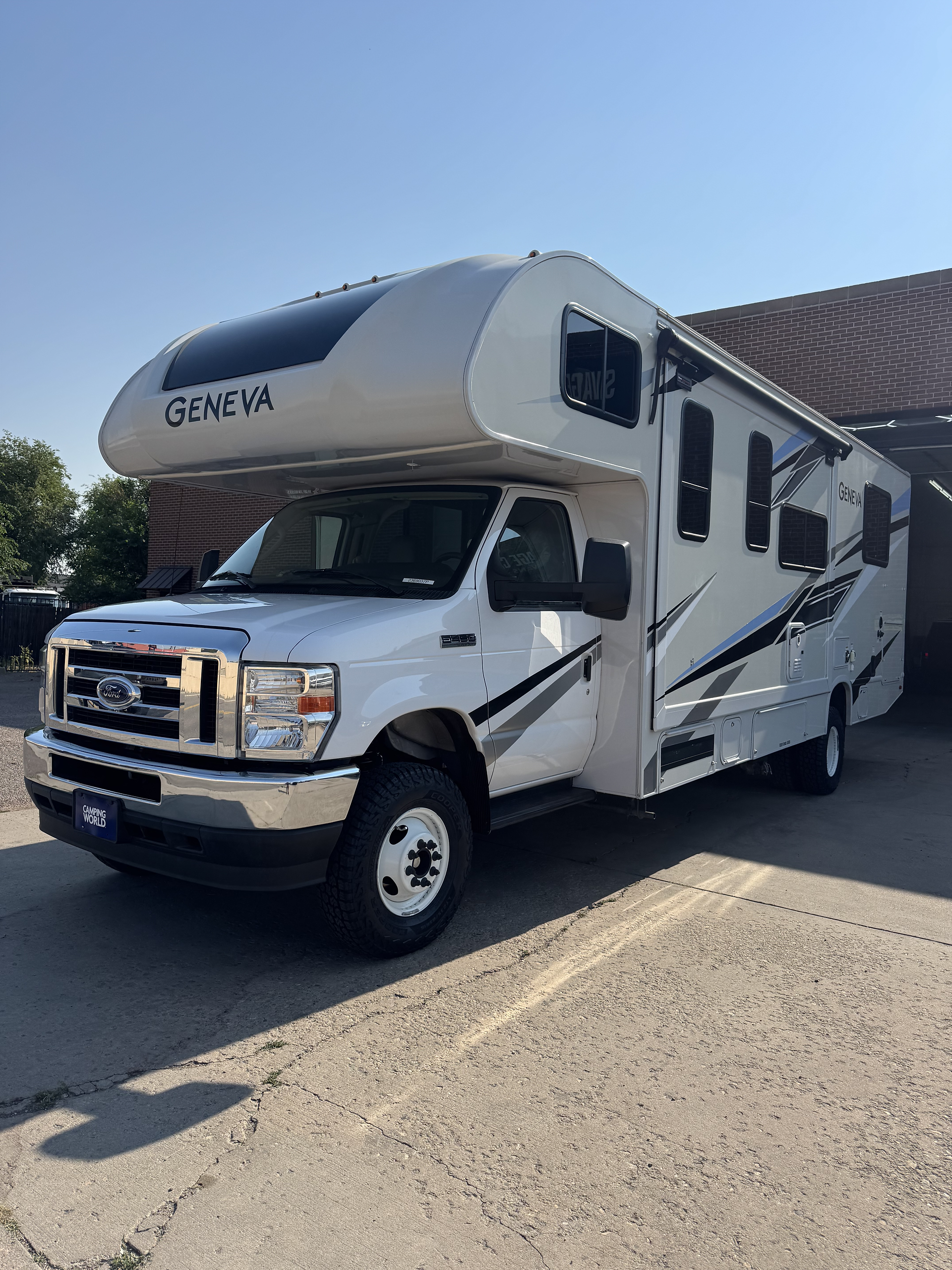 Driver side 3/4 view of Thor Geneva Class C RV with 6" lift kit