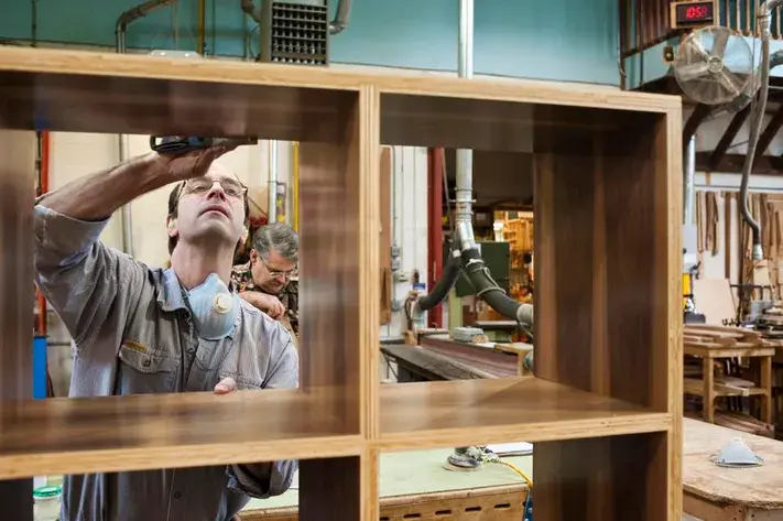 Handyman assembling an eco-friendly wooden shelf with sustainable tools and materials.