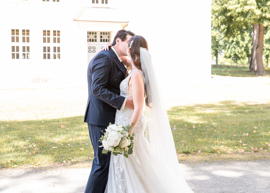 Braut und Bräutigam küssen sich vor Schloss Elsterwerda – romantische Hochzeitsfotografie