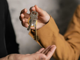 A person, handing keys to another person
