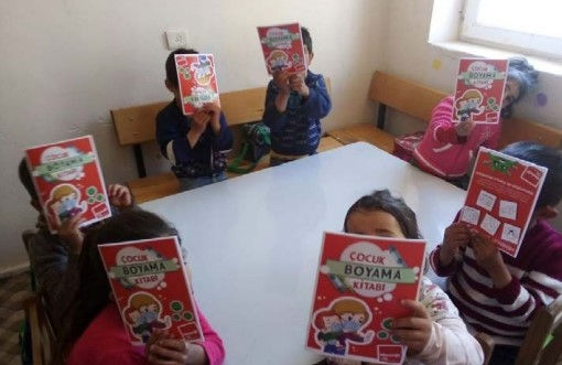 Group of children holding up meningitis awareness colouring book