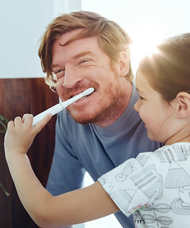 Ragazza che lava i denti del papà
