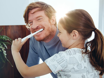 Ragazza che lava i denti del papà