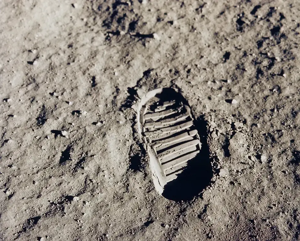 A solitary bootprint on a dusty, gray surface. The stark contrast and texture evoke a sense of solitude and history in a desolate setting.