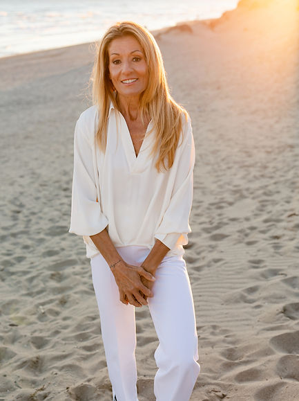 schöne, blonde Frau am Strand in der goldenen Stunde, Claudia Minneci