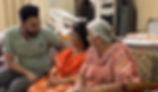 Caring staff member smiling while speaking with an elderly woman at a senior assisted living home.