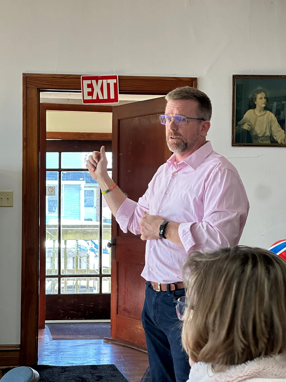 "Steve Morris stands at the front of a room, passionately addressing a crowd about corruption in Hebron’s local government."