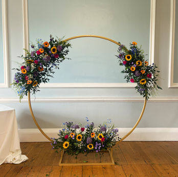 Moorgate arch with 3 floral arrangements attached in bright colours