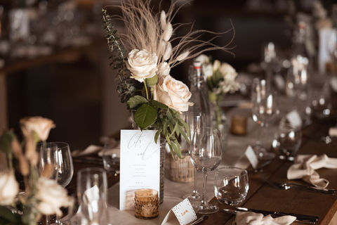 Close up of table setting with ivory roses and dried flowers