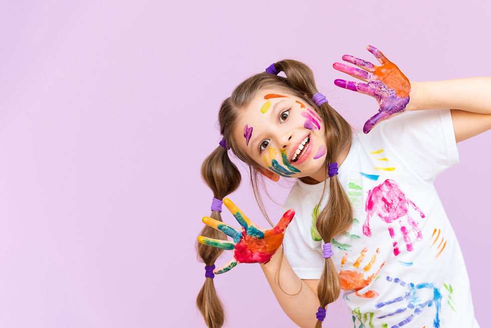 A beautiful little girl stained in multicolored paints on a pink isolated background has f