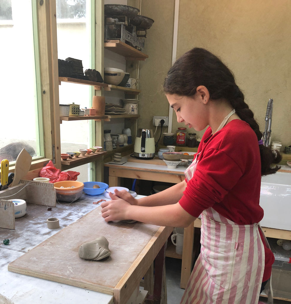 התלמידה לשה חימר על שולחן הלישה