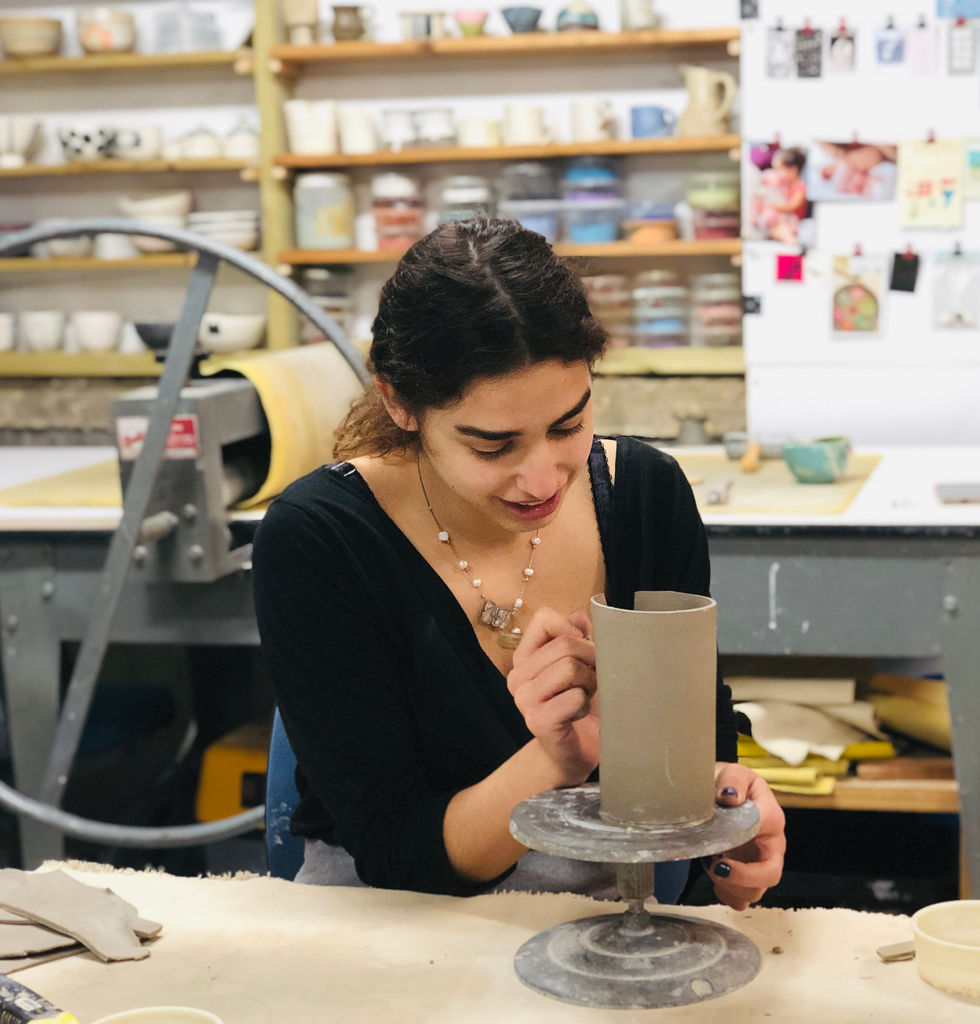 תלמידה בסדנא מכינה כוס גבוהה מחימר