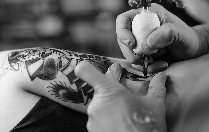 Black and White Image of Tattoo Artist Tattooing a clients arm