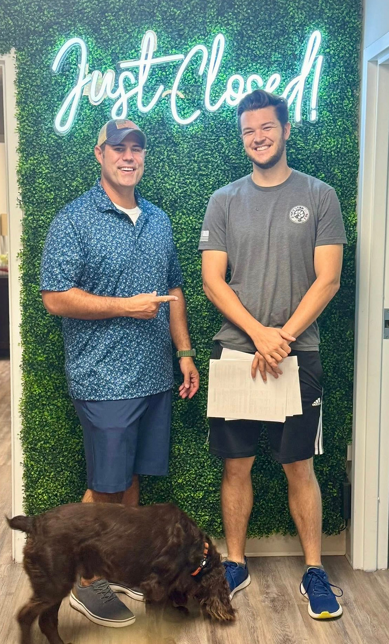 Two men and a dog by a Just Closed Charleston Real Estate sign