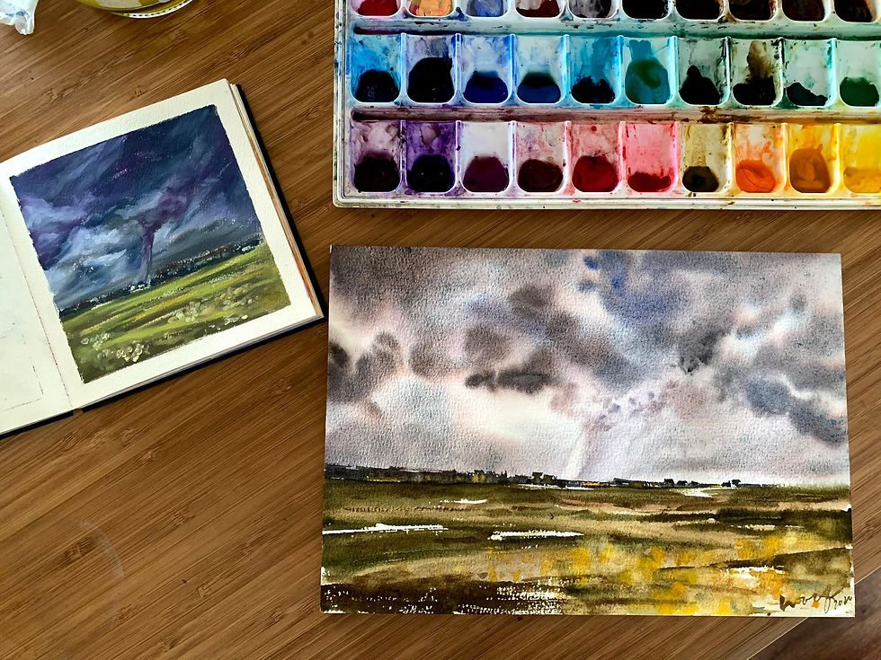 Watercolour pan set with a painting of a green landscape featuring a stormy sky hurricane in the horizon.