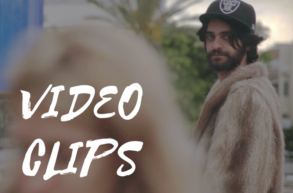 גבר חובש כובע ו מעיל פרווה, כתוב: VIDEO CLIPS, ברקע בניינים בראדר הפקות וידאו