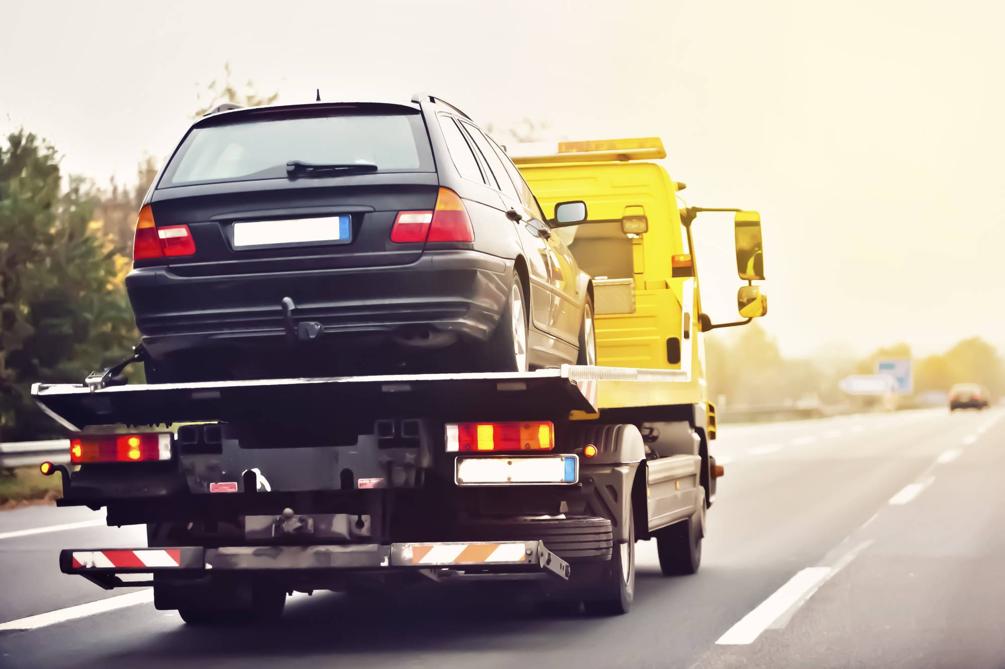 Automobile transportée sur la plateforme jaune d’une dépanneuse