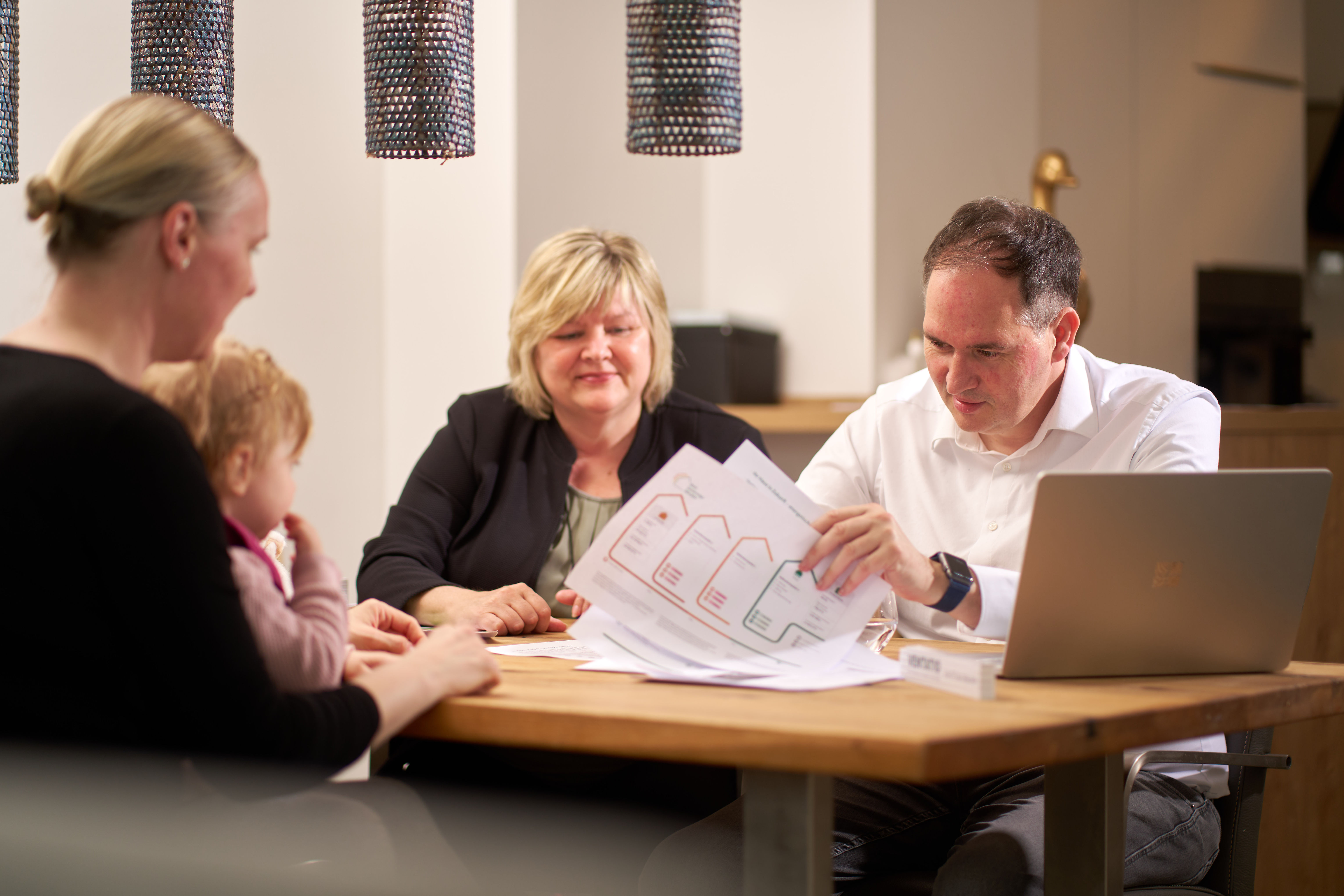 Familie bespricht Sanierungsplan mit Berater