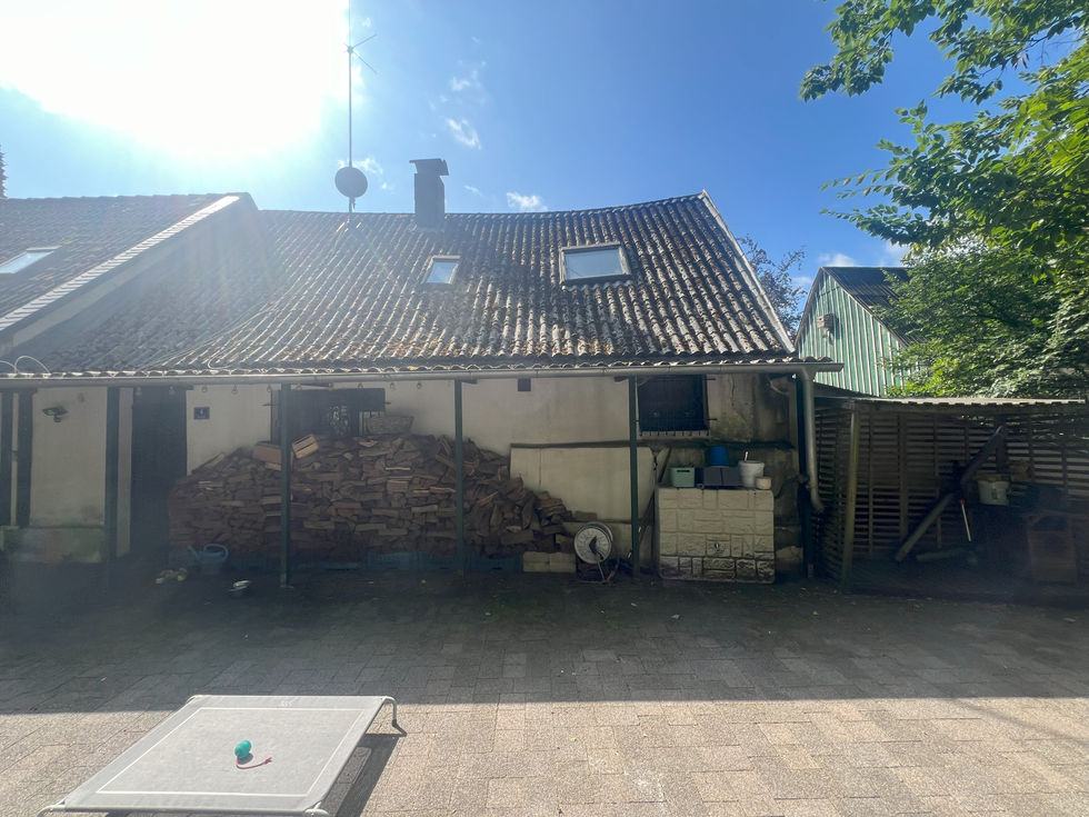 Haus mit Holzstapel und Garten