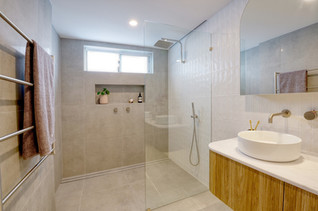 Modern bathroom renovation featuring a spacious walk-in shower, natural wood vanity, and stylish neutral tiles. Designed by Elite Makeovers in Perth, this contemporary space offers a perfect blend of elegance and functionality. Transform your bathroom with expert craftsmanship and premium finishes.