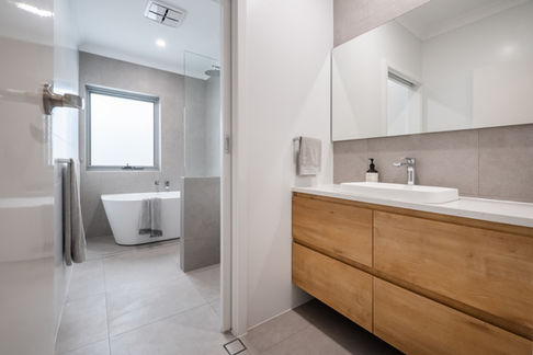 Luxury bathroom renovation in Perth featuring a floating timber vanity, double sinks, freestanding bathtub, and a spacious walk-in shower. Designed by Elite Makeovers, experts in premium bathroom, kitchen, and laundry renovations for high-end homes in Western Australia.