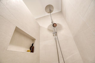 Modern walk-in shower with rainfall showerhead and recessed shelf – part of a premium bathroom renovation by Elite Makeovers in Perth.