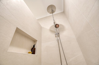 Modern walk-in shower with rainfall showerhead and recessed shelf – part of a premium bathroom renovation by Elite Makeovers in Perth.