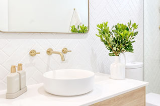 A spacious and elegant bathroom featuring white terrazzo tiles, gold tapware, and a glass shower screen. Designed by Elite Makeovers. Perth bathroom renovations in Dalkeith.