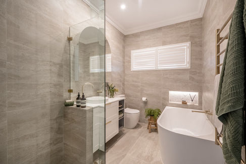 Modern luxury bathroom renovation in Perth featuring a freestanding bathtub, glass shower enclosure, and elegant gold fixtures.
