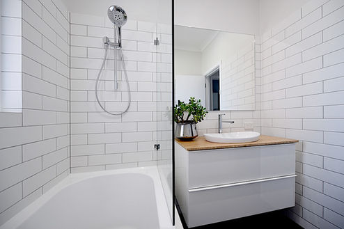 Modern bathroom renovation featuring a sleek walk-in shower, white subway tiles, and a stylish floating vanity with a timber benchtop. Designed for elegance and functionality by Elite Makeovers in Perth.