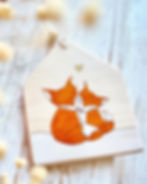 un panneau en bois recyclé représentant 2 renards se faisant un calin, avec un petit coeur