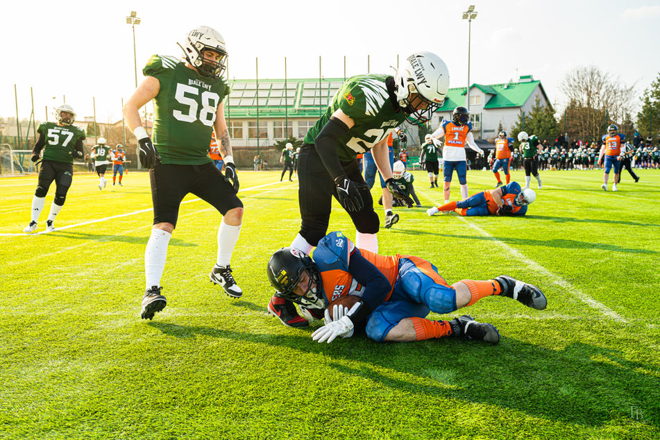 Tackling och kamp om bollen under en match i amerikansk fotboll fångade av en eventfotograf.