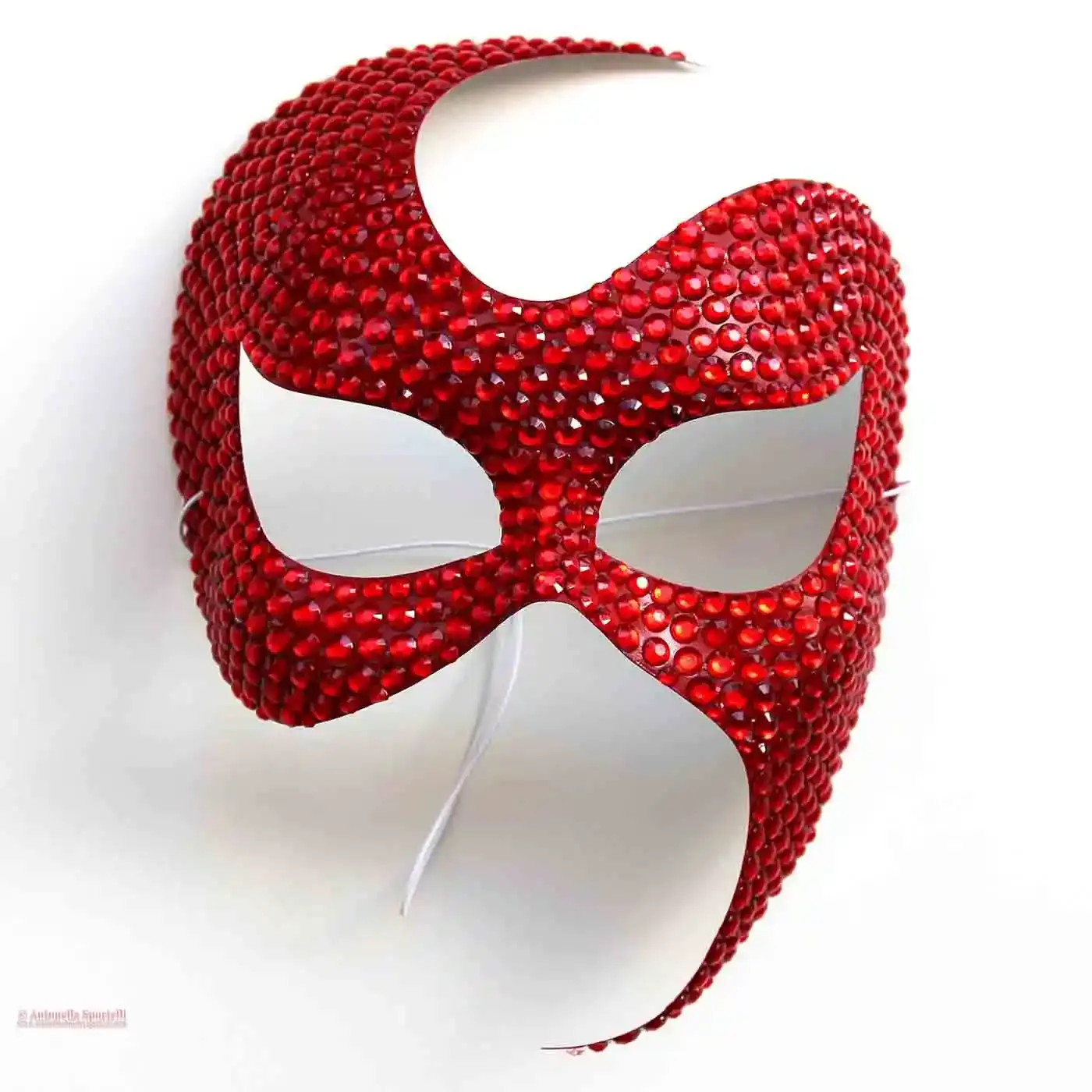 Maschera rossa elegante artigianale ricoperta di strass rossi, vista frontale su sfondo neutro