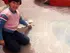 Fotografia di me stessa da bambina, mentre disegno con un gessetto sull'asfalto, simbolo del gioco e dell'inizio dell'espressione artistica personale