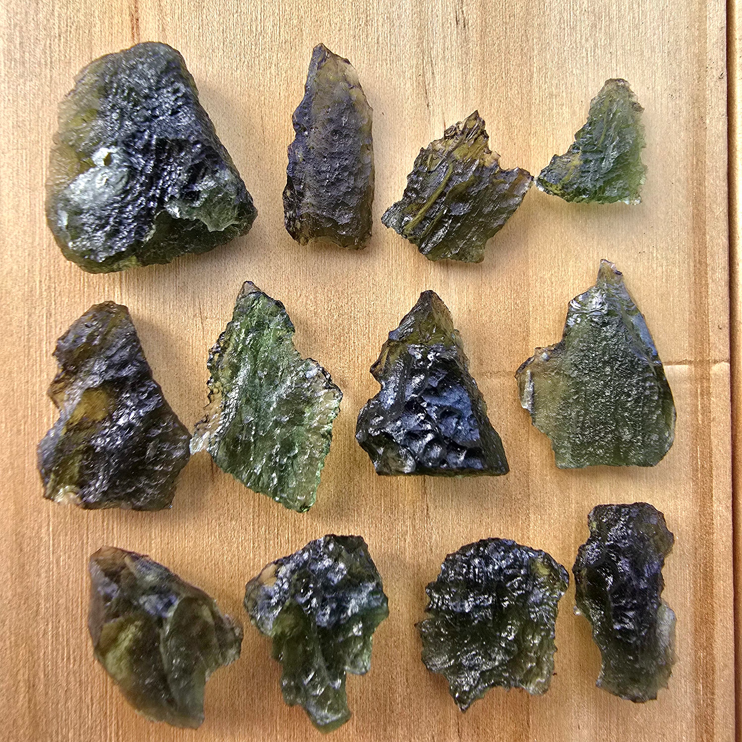 Greenish moldavite bundle on wood