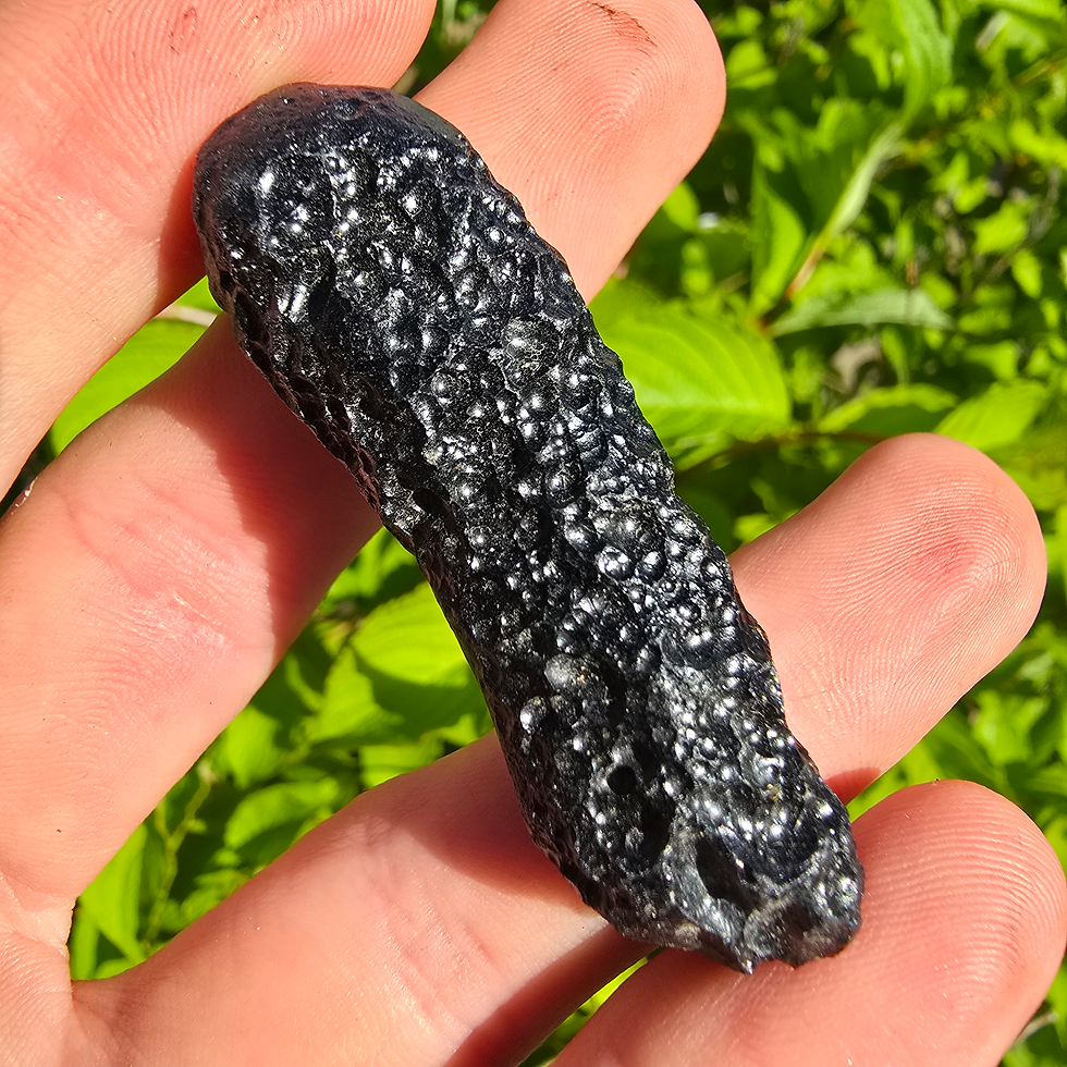 Thumbnail: Hand holding a dark, textured Philippinite tektite